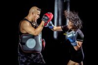 woman punching the hand of man wearing training gloves